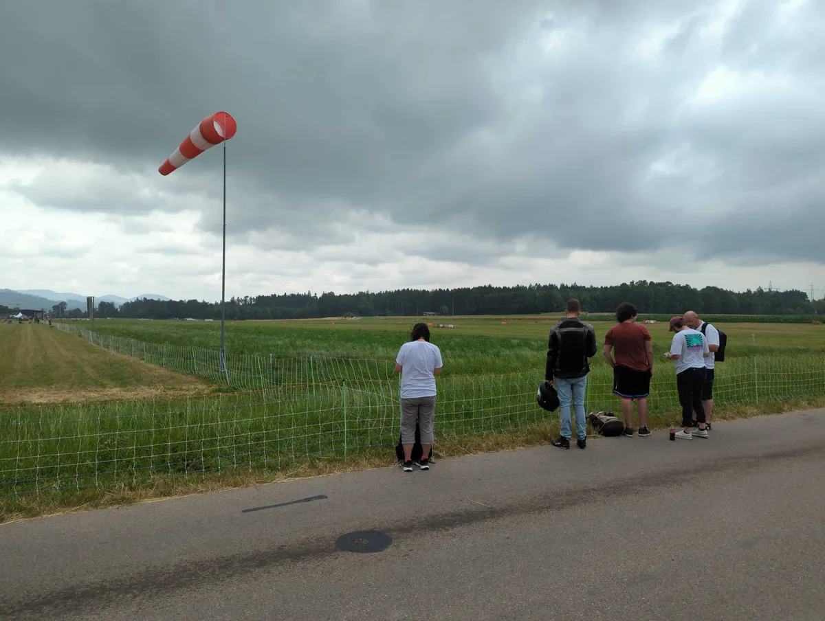 Vier Menschen stehen am Flugplatz Speck.
